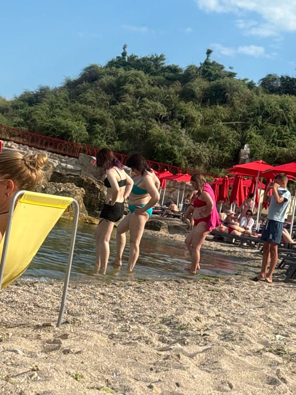 Sunny afternoon at an Odesa beach with umbrellas and rocky coastline
