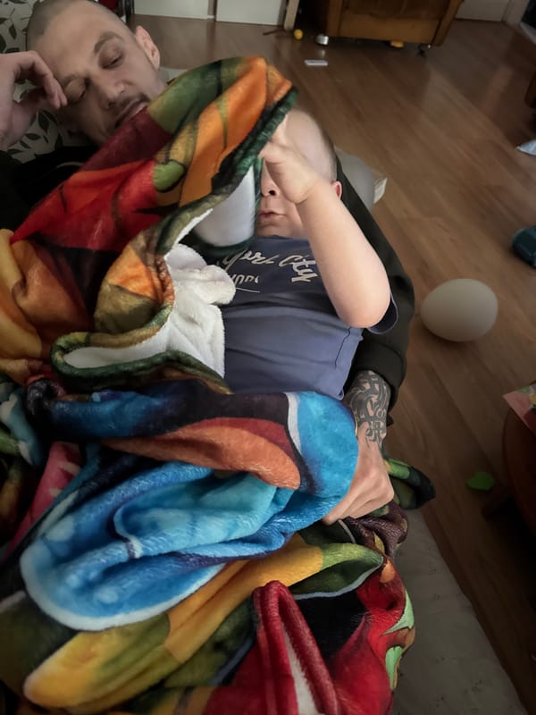 Man and child rest together on blanket in Sofia