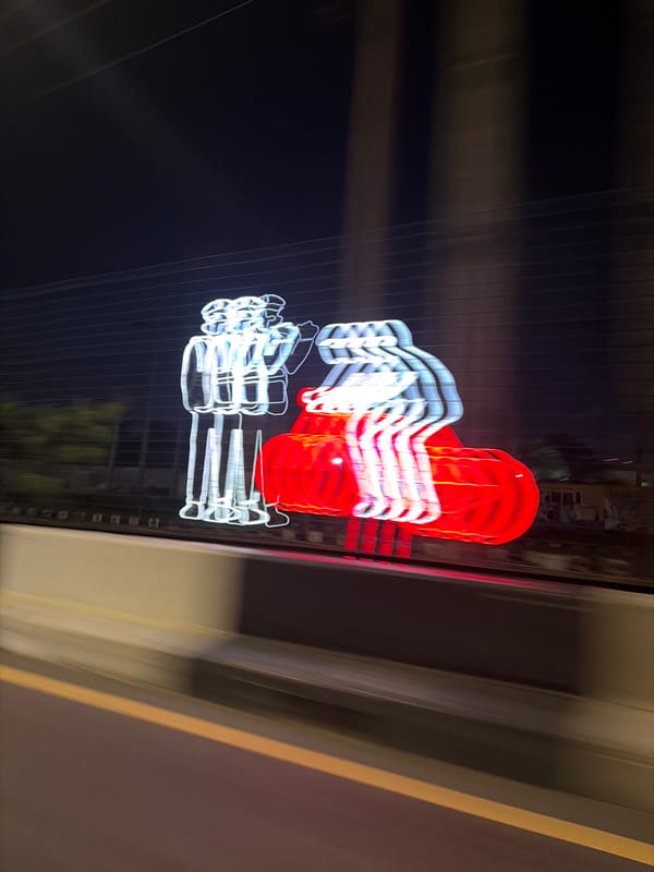 Blurred neon sign photographed from moving vehicle in Lagos