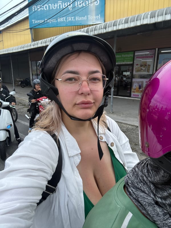 Riding through Karon's streets past shops and hillside housing