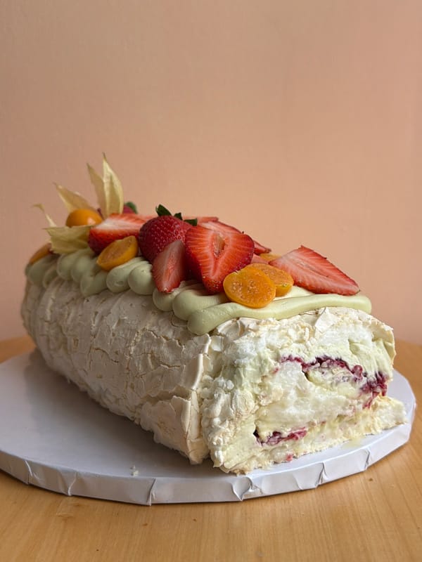 Baker prepares decorated meringue roulade cake in Tel Aviv kitchen