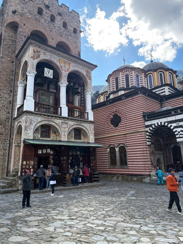 Morning visitors gather at Bulgaria's historic Rila Monastery courtyard