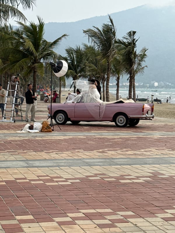 Professional photoshoot with vintage pink convertible at Da Nang beach