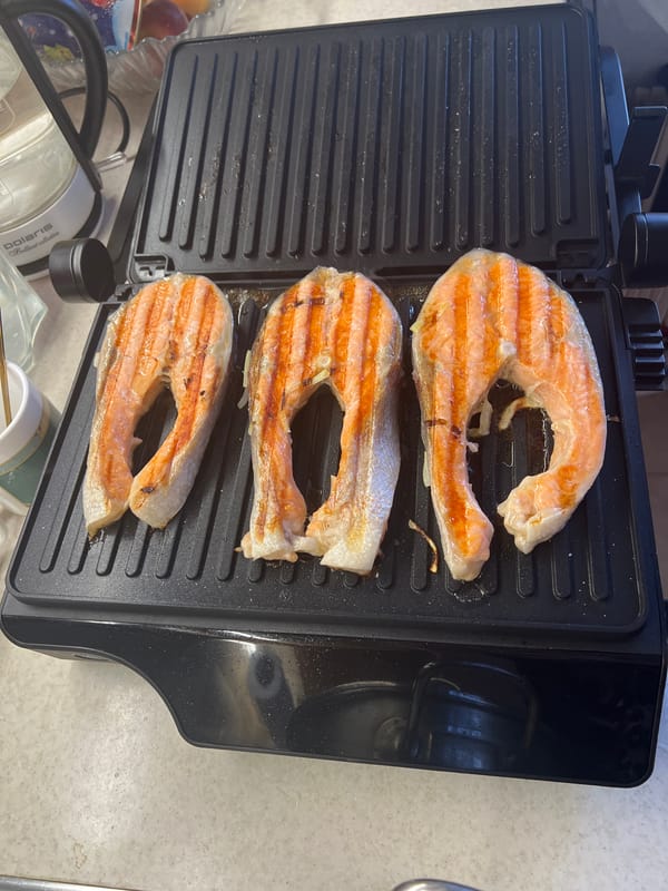 Moscow resident prepares grilled salmon lunch with vegetables
