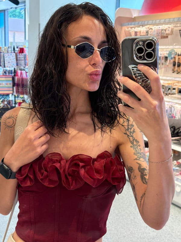 Woman takes selfies in Pleven wearing red top, sunglasses
