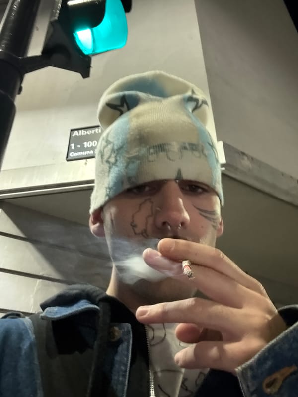 Person with facial tattoos photographed smoking in Buenos Aires