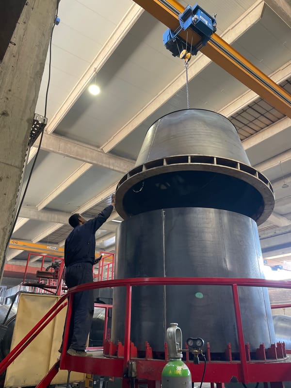 Crane moves large metal cylinder in Montenegro industrial facility