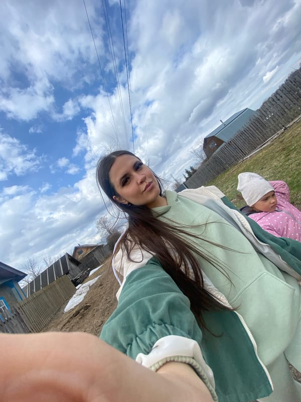 Woman takes selfie with child on rural road in Zhigalki