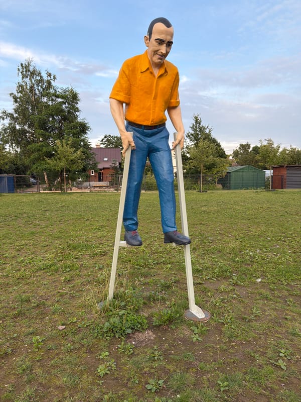Stilt-mounted figural statues in an outdoor Vilnius setting