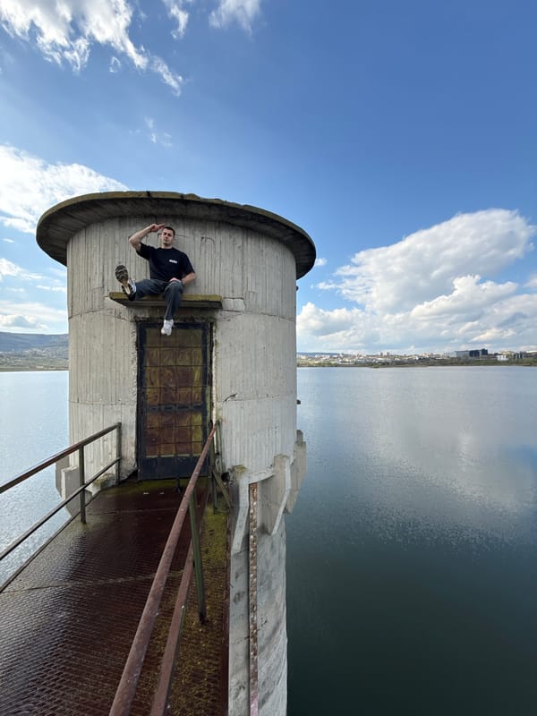 Man sits on concrete ledge overlooking water in Shumen