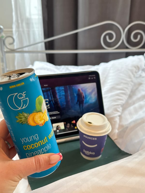 Person enjoys coconut water drink with tablet in Krakow