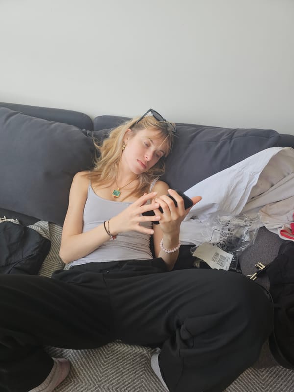 Woman rests on sofa with phone in Pantin