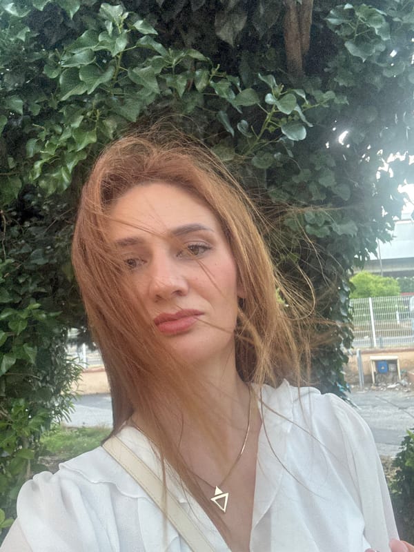 Woman films selfies on flower-lined street at dusk