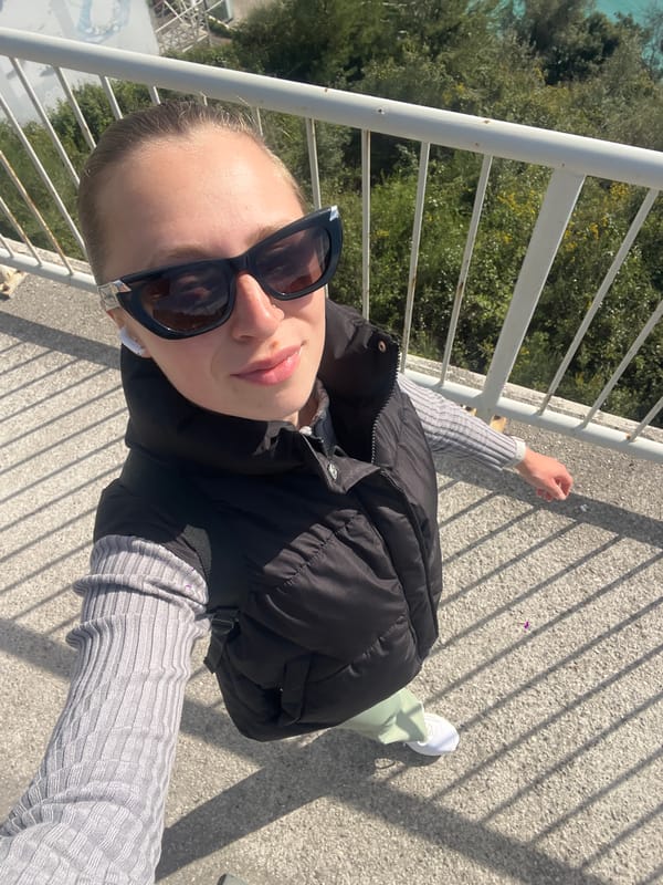 Tourist captures selfie on Budva footbridge amid coastal scenery