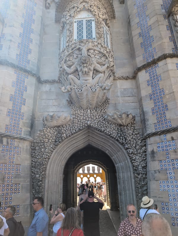 Tourists explore Pena Palace's yellow exterior in Sintra