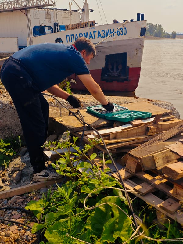 River dock crews unload pontoons and cargo in Krasnoyarsk