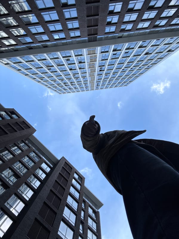 Person gazes skyward in Moscow courtyard amid modern towers