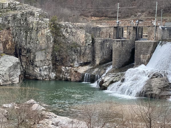 Visitors document waterfall and dam structure near Paspal, Bulgaria