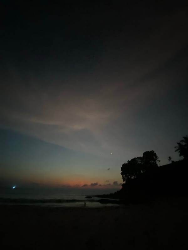 Twilight beach scene with crescent moon observed in Thailand