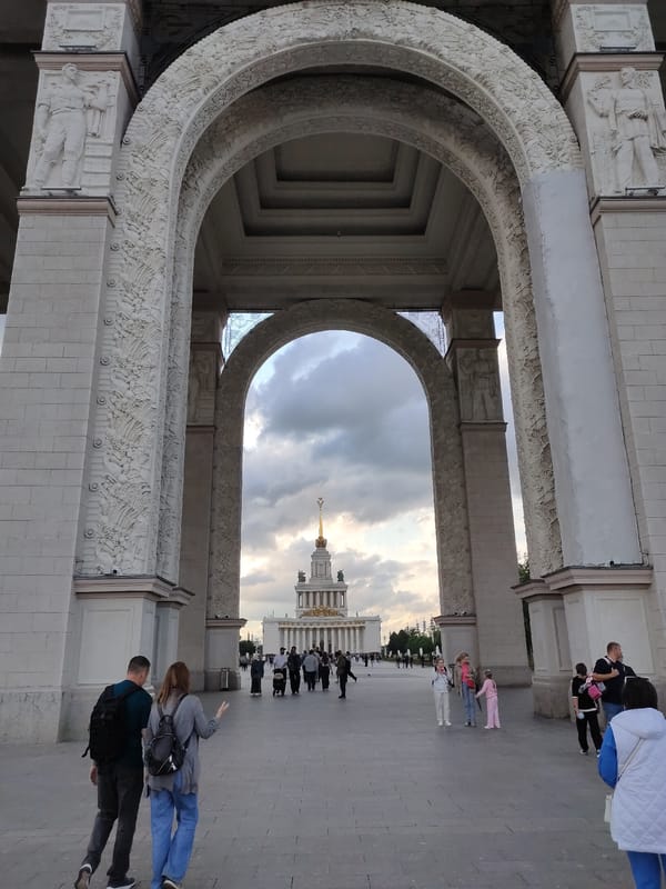 Ornate archway, fountain, and cherry trees at a grand public landmark