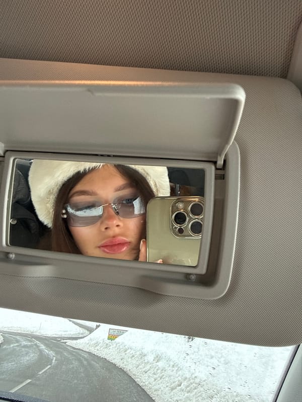 Woman takes vanity mirror selfie in Courchevel vehicle