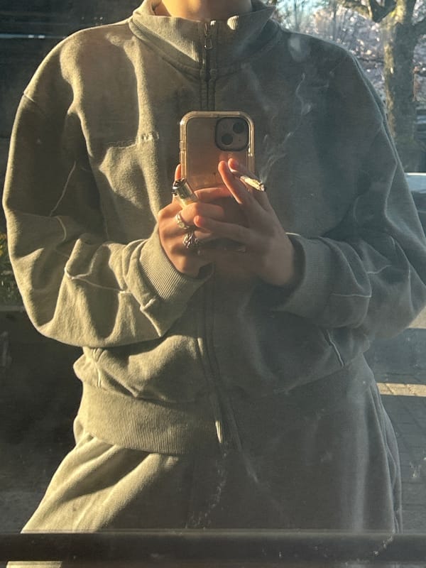 Woman smoking, using phone captured in Vancouver reflections