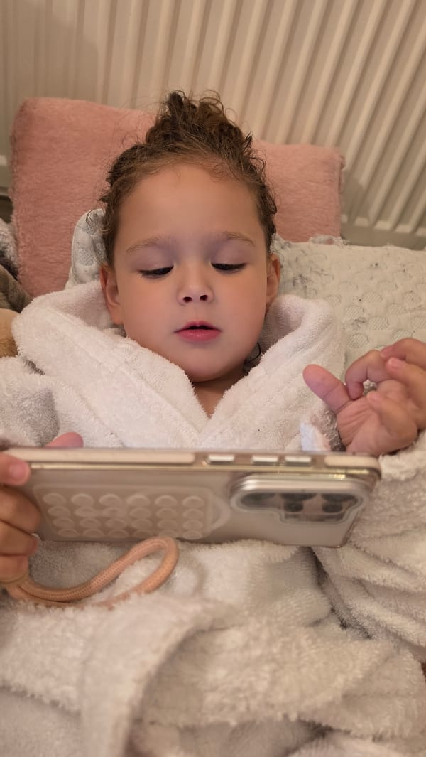 Child rests with smartphone before sleeping in London home