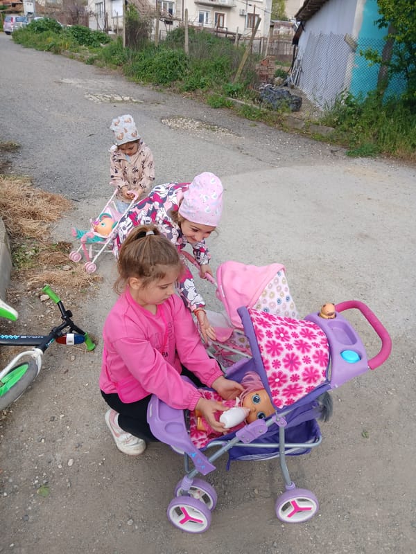 Children play with toys on residential streets in Obrochishte