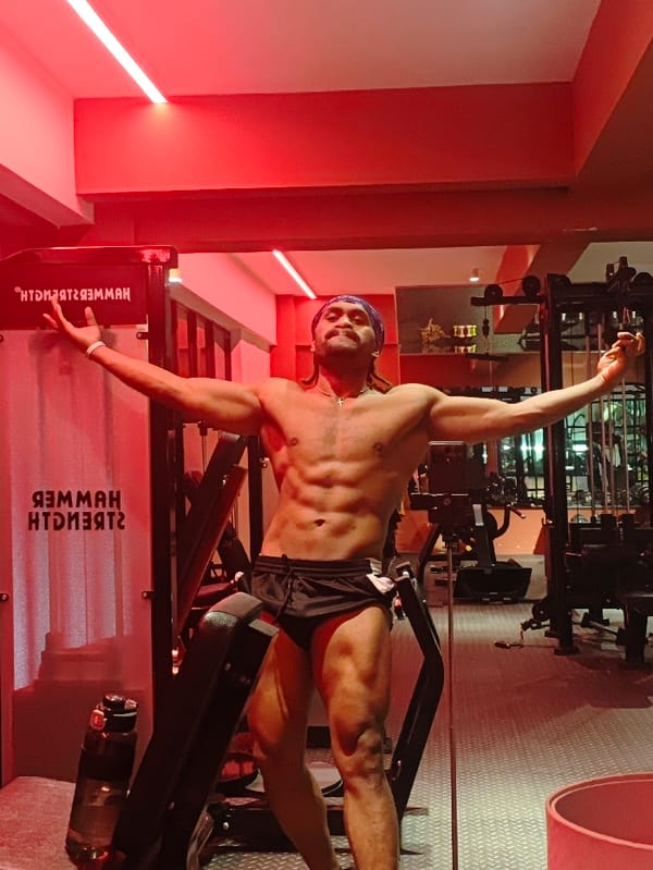 Man works out at red-lit Chongqing gym with cats present