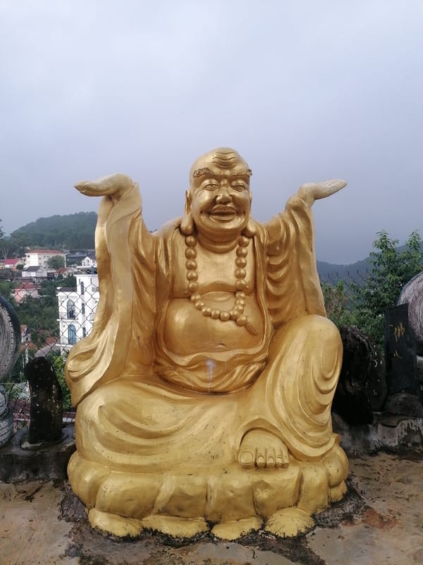 Tourist documents Buddhist temple complex in misty Da Lat
