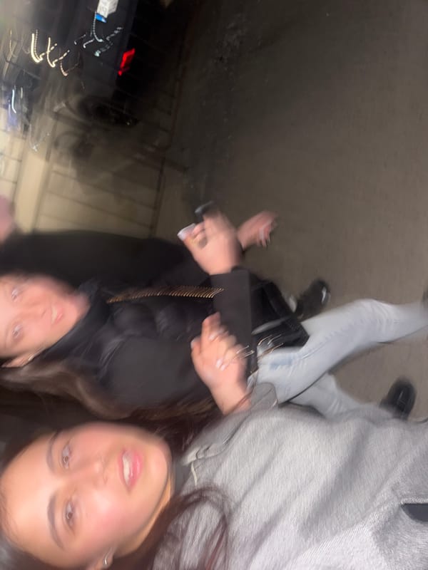 Two women take nighttime selfie outdoors