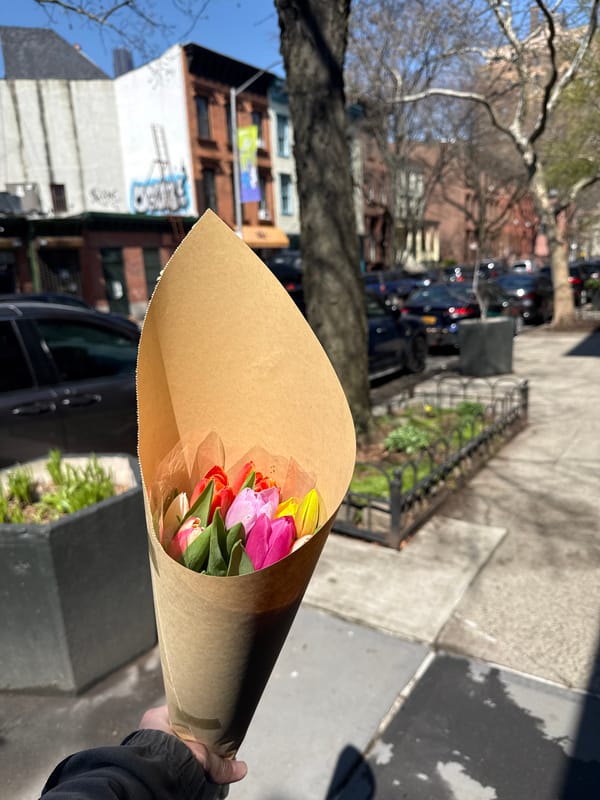 Person carries tulip bouquet near NYC subway station