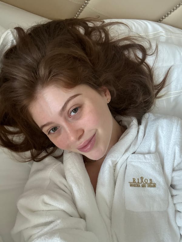 Woman in hotel robe rests in Abu Dhabi marina accommodation