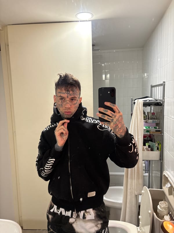 Tattooed individual takes bathroom selfie in Buenos Aires
