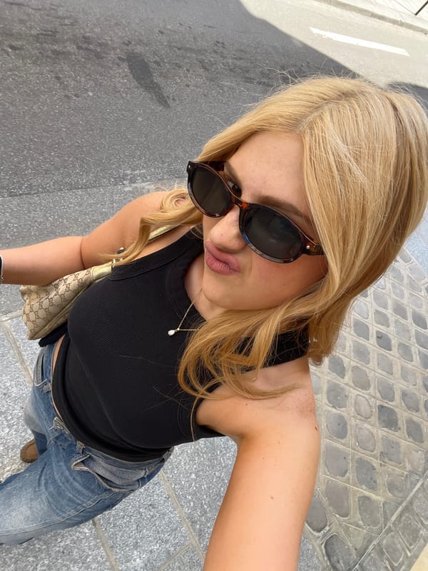 Woman takes selfie during afternoon stroll past Paris cafes