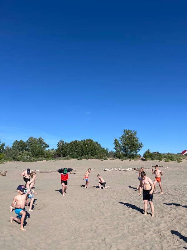 Kids play and dig on a Krasnoturansk beach on a sunny morning