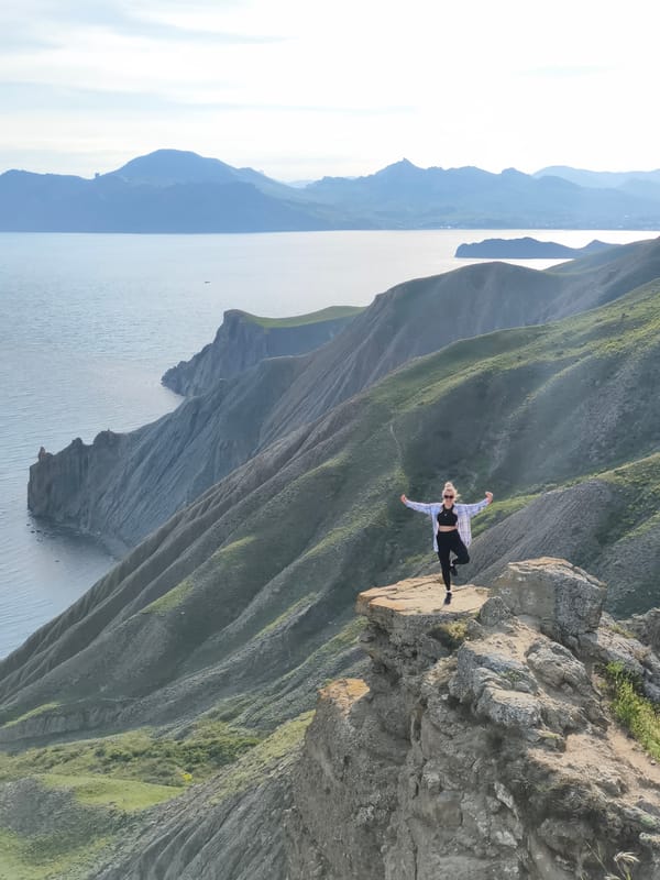 Tourist explores coastal hills near Ukrainian settlement on spring afternoon