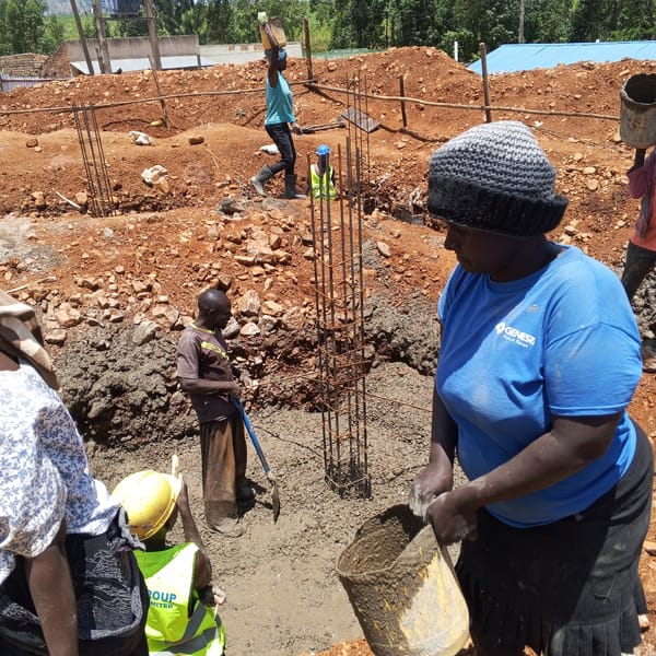 Construction workers pour concrete foundation in Borabu Chitago ward