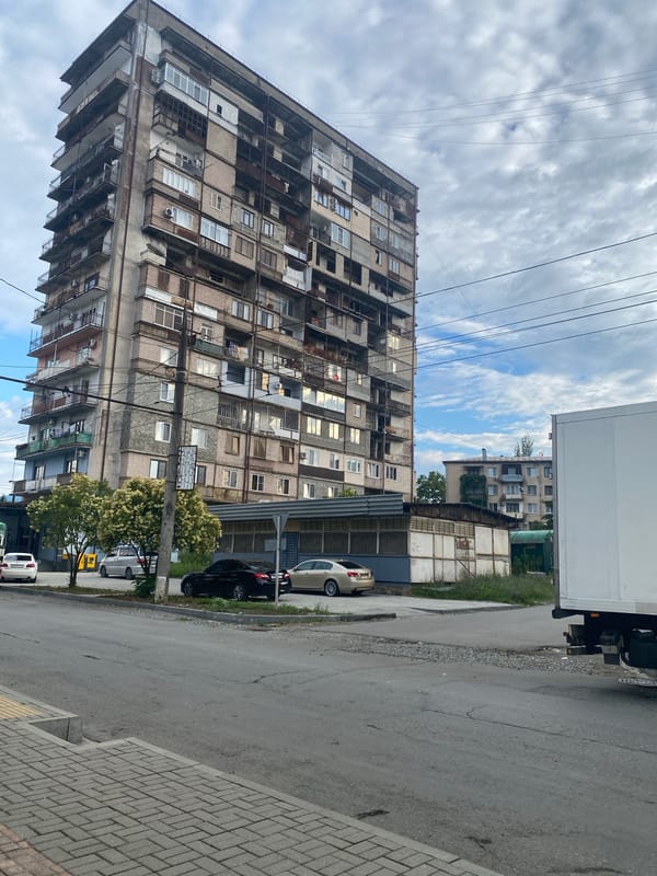 Quiet urban block, cloudy morning, apartment complex and street life