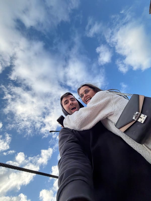 Low-angle sky photography captures two people in Machico, Portugal