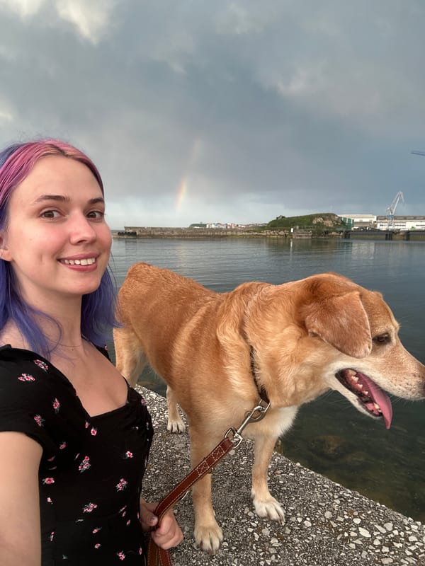 Woman and dog pose for photos under rainbow in Gijón
