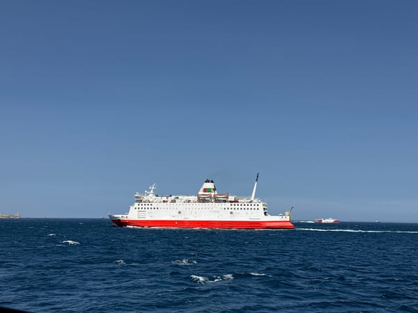 Red and white ferry crossing calm blue waters off Spain