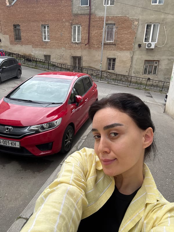 Woman takes selfie in overcast Tbilisi street scene