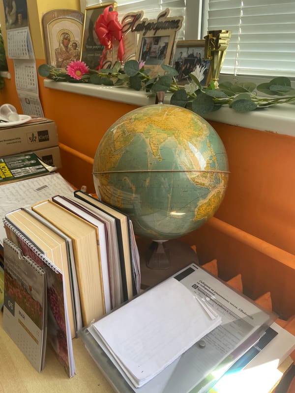 Person documents indoor space with vintage globe and wooden floors
