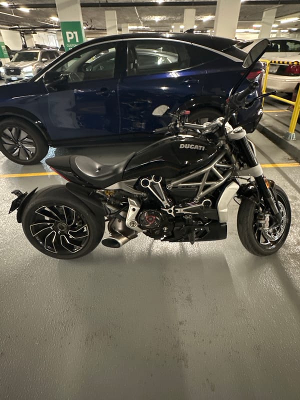 Ducati motorcycle and blue car parked in Burnaby garage