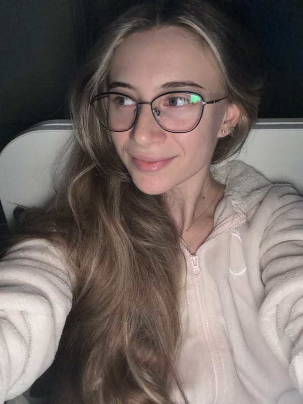 Young woman takes playful selfies in pink onesie