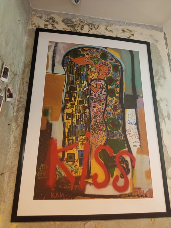 Framed abstract painting documented against partially painted indoor wall