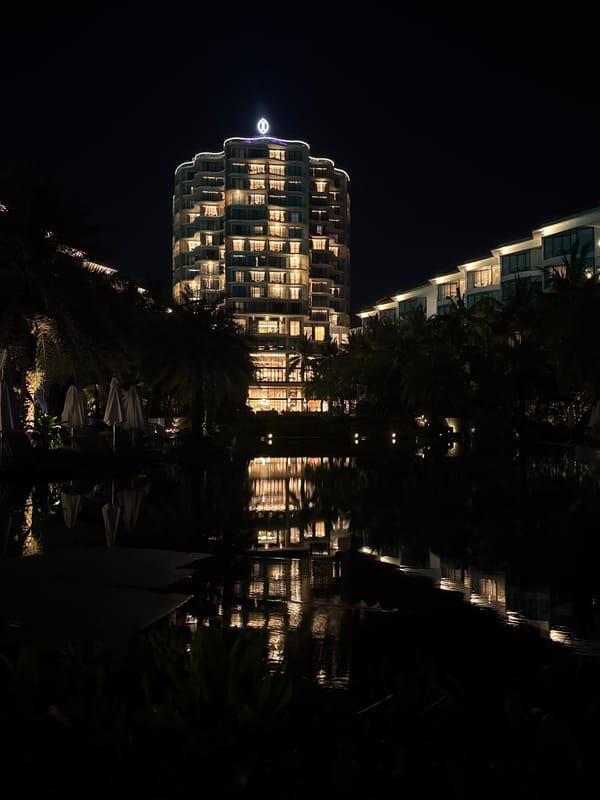 Illuminated buildings reflected in water captured in Phú Quốc