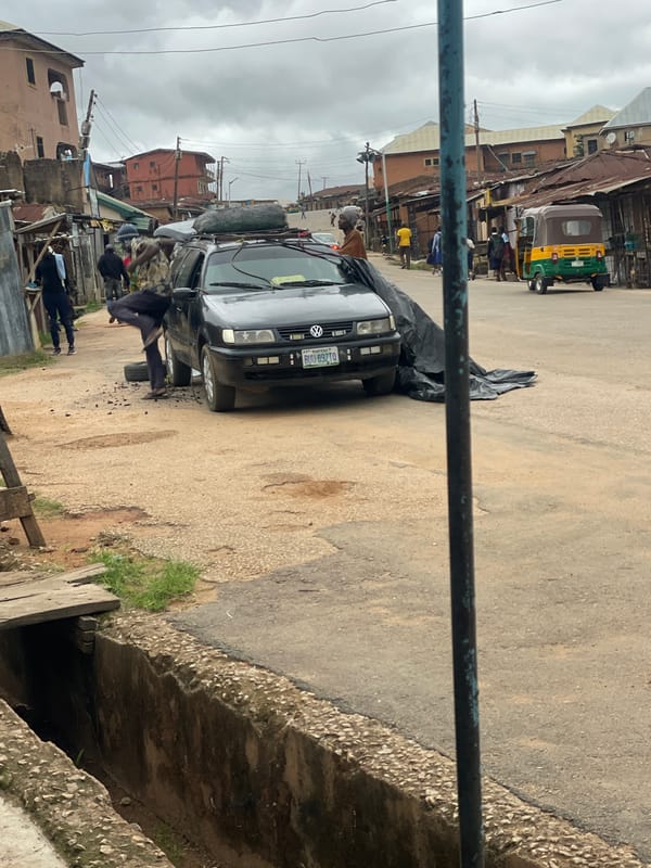 Roadside mechanics repair motorcycles, tires in Jos Nigeria morning