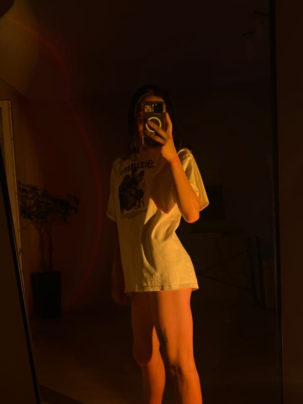 Mirror selfies in a warmly lit Ternopil room, graphic tee close-up